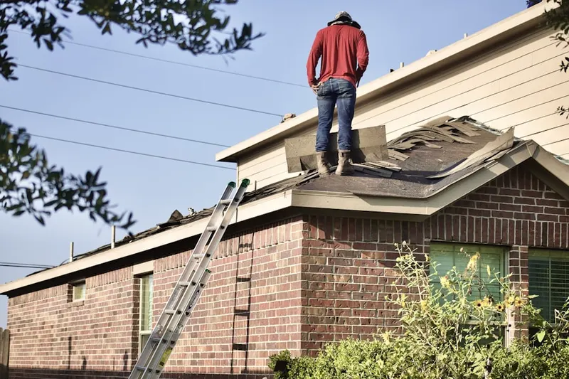 Professional roofer working on a residential roof in Fredonia